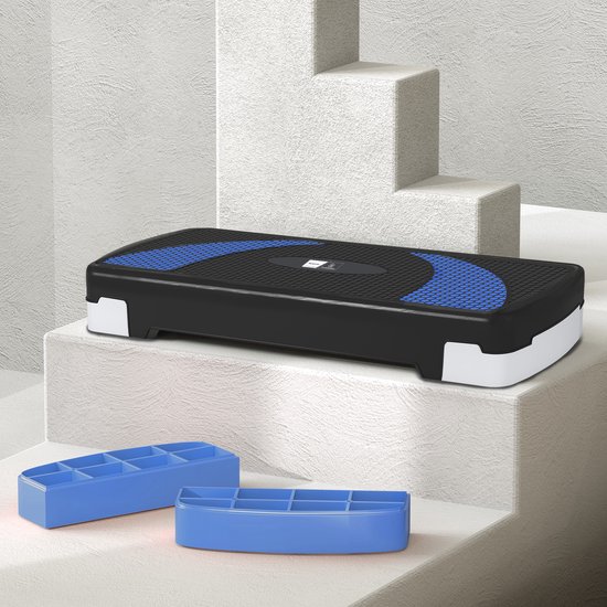 Zwarte aerobic step met blauwe accenten, staand op witte trappen.