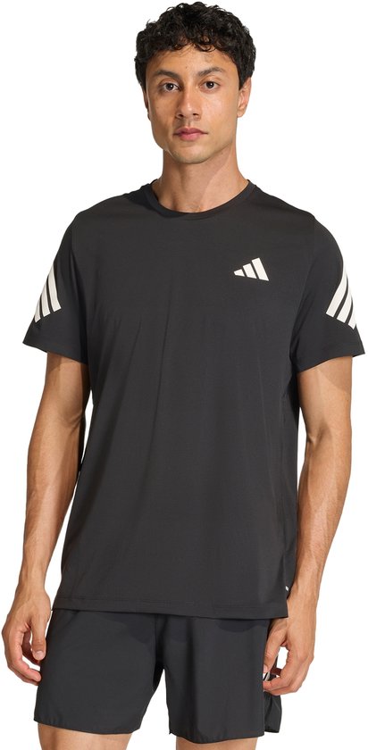 Man in zwart Adidas sportshirt met drievoudige witte strepen op de mouwen en het Adidas logo op de borst.