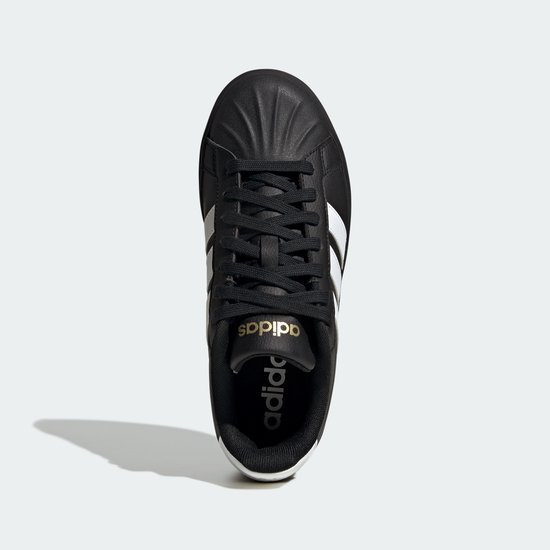 Bovenaanzicht van een zwarte damessneaker met witte Adidas-strepen, gouden details en dikke zool.