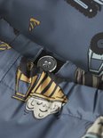Detail van blauw regenpak met opdruk van bouwmachines, met zichtbare naad en knoop.