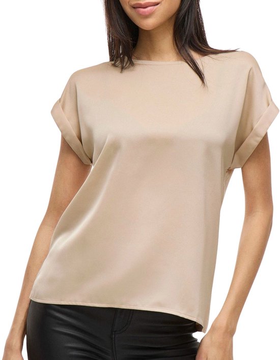 Femme en haut satiné beige à manches retroussées et pantalon en cuir noir.