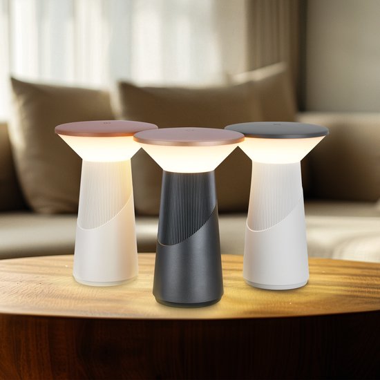 Drie Pilia tafellampen in wit, antraciet en wit met bronzen dop, staand op een houten tafel.