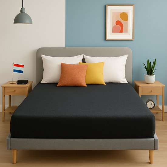 Un drap-housse gris anthracite sur un lit avec des coussins blancs et jaunes. Un drapeau néerlandais est accroché à la table de chevet.