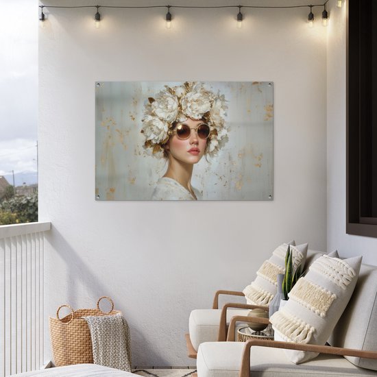 Meisje met zonnebril en grote witte bloemenkrans op een rustige, gouden achtergrond, hangend op een balkon.