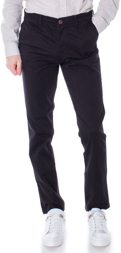 Zwarte slim fit chino broek, gedragen met een lichtgrijs overhemd en witte sneakers.