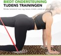 Vrouw doet oefening op fitnessmat met panterprint. Mat biedt ondersteuning voor rug, benen en knieën.