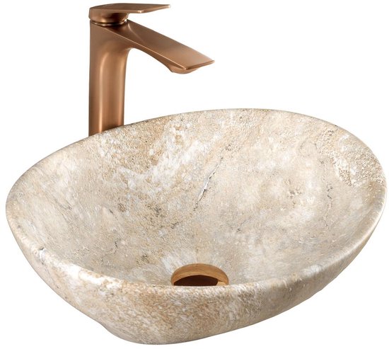 Lavabo ovale en pierre beige aux motifs naturels, avec un robinet en bronze.