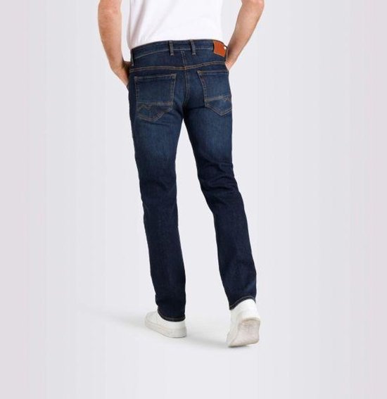Donkerblauwe jeans gedragen door een man, gezien vanaf de achterkant. De jeans heeft oranje stiksels en een bruin label op de achterkant.