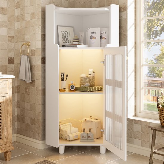 Witte hoekkast met open deur, gevuld met toiletartikelen, handdoeken en manden in een badkamer.