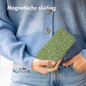 Vrouw die een groen telefoonhoesje met bladerpatroon vasthoudt.