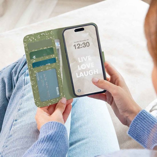 Open groen telefoonhoesje met kaarthouders en een telefoon met klok.