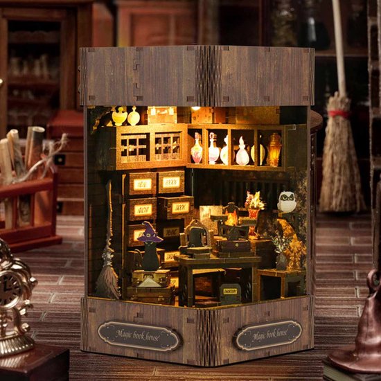 Een verlicht miniatuur huisje met magische voorwerpen, met de tekst 'Magic book house'.