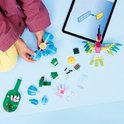 Des mains d'enfants construisent avec des briques LEGO, avec une fleur bleue, une fleur rose et un colibri en construction.