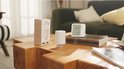 Aqara radiatorthermostaat met verpakking en een digitaal display op een houten tafel.