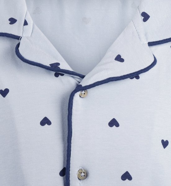 Lichtblauwe pyjamatop met donkerblauwe hartjesprint, donkerblauwe bies en knoopsluiting.