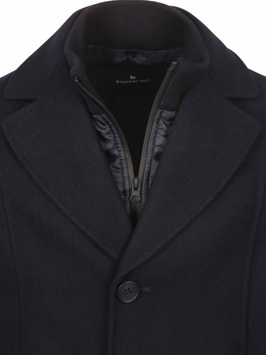 Detail van donkerblauwe wollen jas met rits en Steppin' Out logo in de kraag.