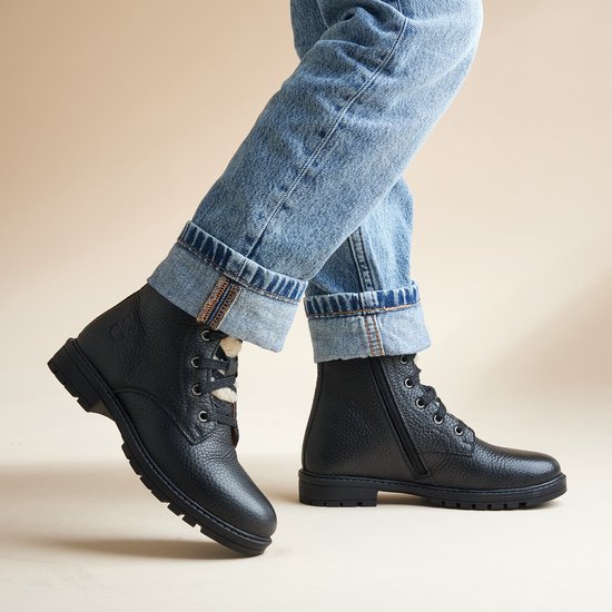 Model met zwarte leren veterboots met teddy voering en jeans.