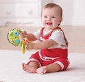 Lachende baby in rood-wit gestreept pakje speelt met groene VTech rammelsleutels.