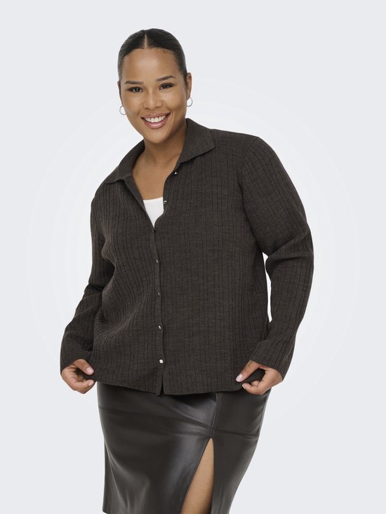 Le mannequin porte un cardigan marron en tricot avec des boutons et un col. Dessous, un haut blanc et une jupe en cuir noire fendue.