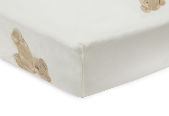 Drap housse crème avec un imprimé ours en peluche couleur sable, détail du coin.