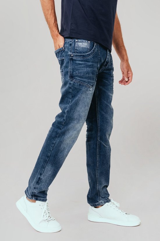 Man in een blauwe jeans met stone wash used look. Gedetailleerde naden en zakken op de voorkant.