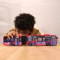 Jongen raakt rode dubbele stadsbus aan. Bus met 'ELECTRIC CITY LINE', blauwe details en accordeonverbinding.