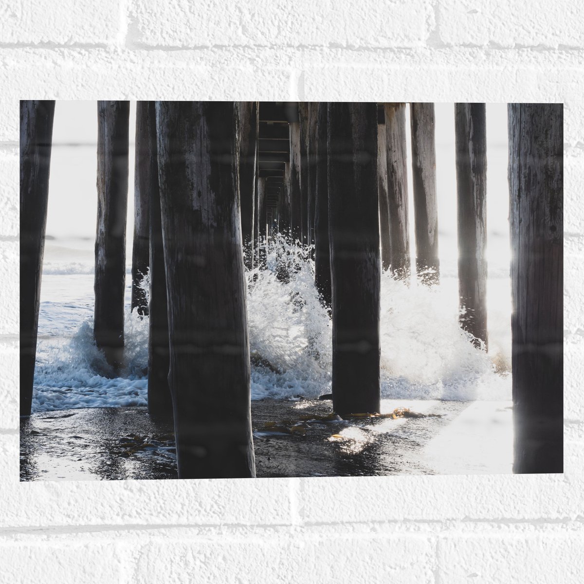 Muursticker - Water klots4end tegen Houten Palen in de Zee - 40x30 cm Foto op Muursticker