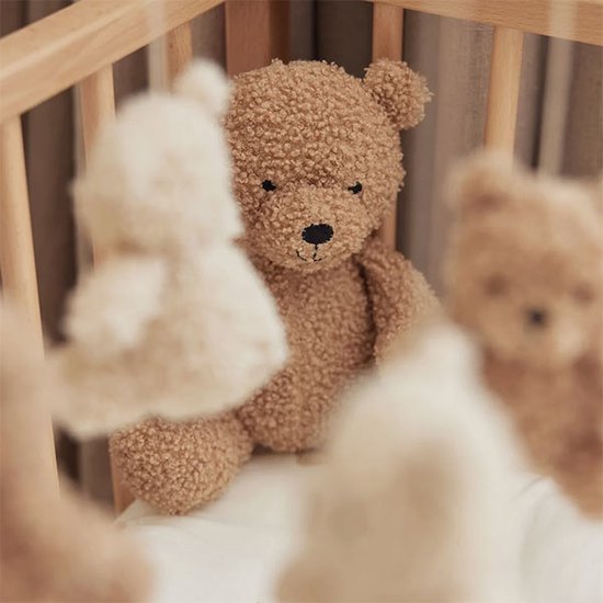 Een bruine teddybeer met zwarte oogjes en neus, zacht en pluizig.
