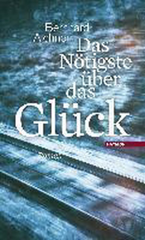 Boek "Das Nötigste über das Glück" met titel in witte letters op een wazige achtergrond van spoorrails.