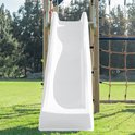 Witte glijbaan van een klimtoestel in een groene tuin, met een blauwe rand aan de bovenkant.