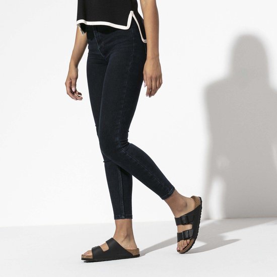 Vrouw met zwarte Birkenstock Arizona slippers aan, met jeans.