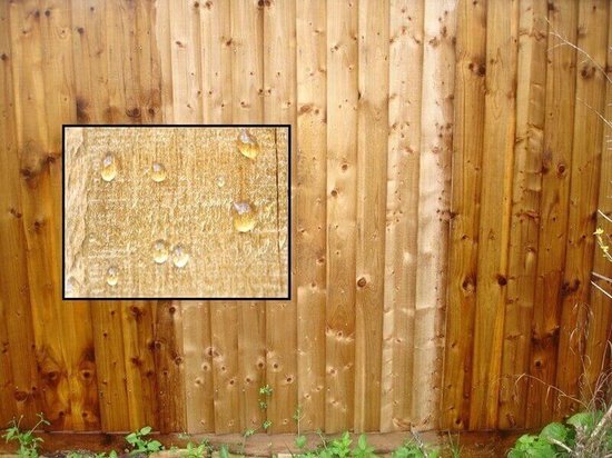 Houten schutting met ingekaderde close-up van waterdruppels op hout.