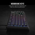Zwart gaming toetsenbord met verlichte membrane toetsen, getoond in een donkere omgeving.