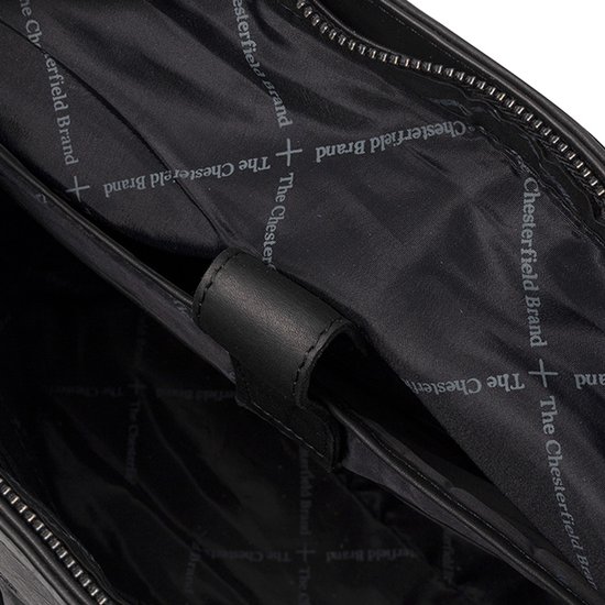 Binnenkant van een zwarte leren tas met logo op de voering en compartimenten, close-up.