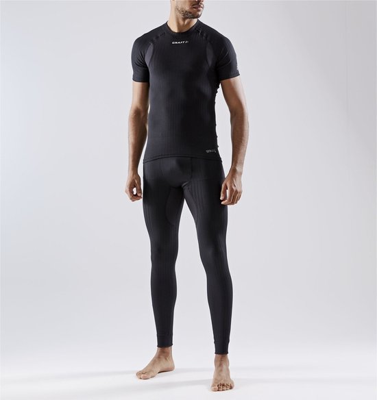 Man met korte mouwen thermoshirt en thermobroek, beide zwart met ribbelstructuur en logo op borst.