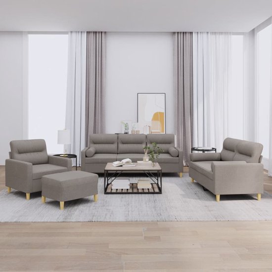 Een taupe stoffen loungeset, bestaande uit een fauteuil, poef, tweezitsbank en driezitsbank, opgesteld in een woonkamer met decoraties.