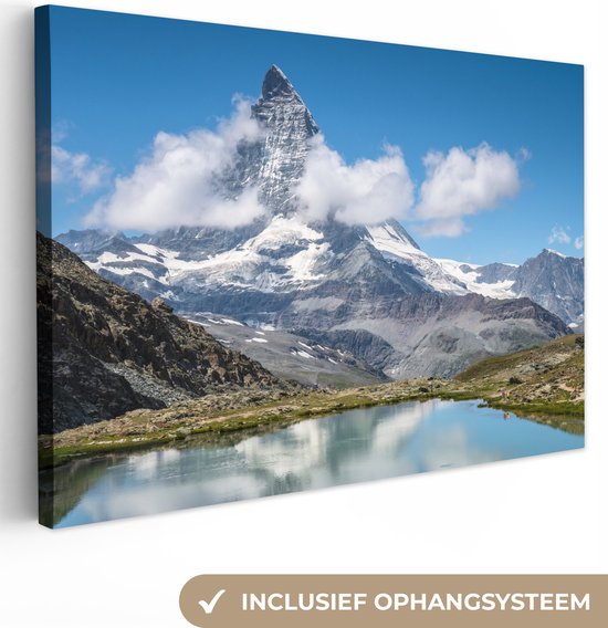 Een canvas met de Zwitserse Matterhorn bergtop, omhuld door wolken, weerspiegeld in een rustig meer, inclusief ophangsysteem.