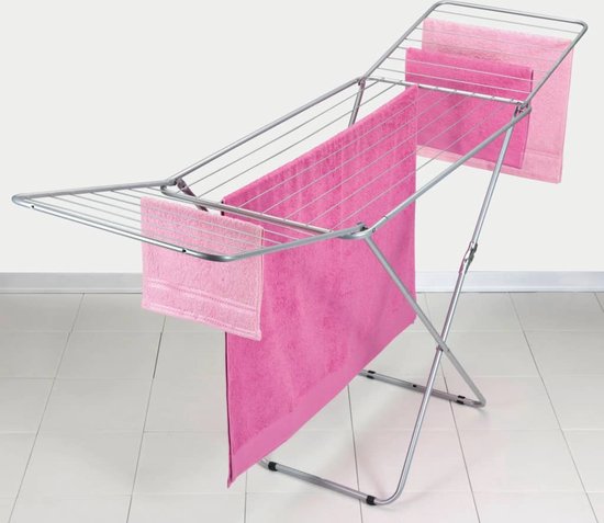 Inklapbaar droogrek met roze handdoeken.
