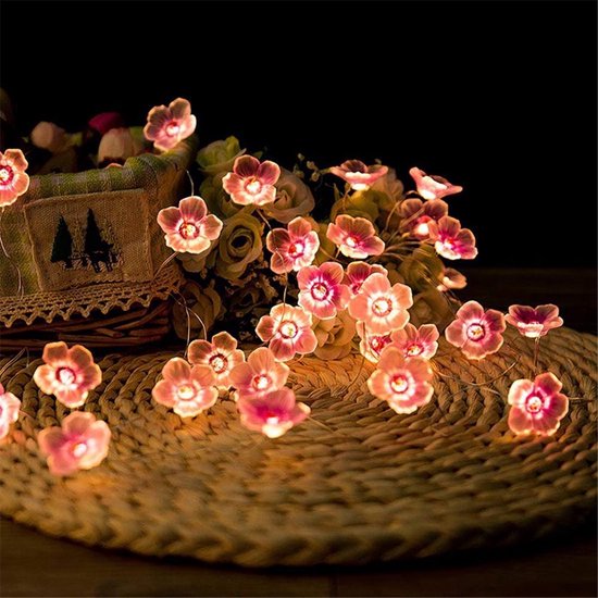 Een lichtsnoer met 20 roze bloemenlampjes, warm en sfeervol verlicht.