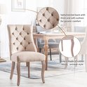 Beige fluwelen eetkamerstoel met knopquilting. Gestoffeerde rug met dik kussen. Antieke stijl rubberhouten poten.