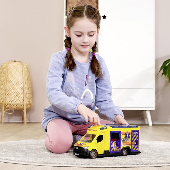 Meisje met vlechten speelt met een gele ambulance met blauwe deuren.