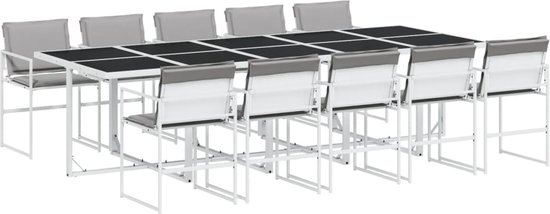 Buiten eethoek met lange tafel en 10 witte stoelen met grijze kussens.