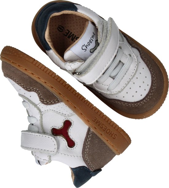 Twee witte sneakers met bruine suède randen, klittenbandsluiting en een rode Y-vormige applicatie.