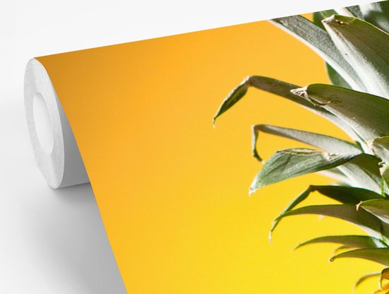 Couleurs jaunes et vertes d'un ananas sur fond jaune Papier peint photo vinyle largeur 600 cm x hauteur 400 cm - Tirage photo sur papier peint (disponible en 7 tailles)