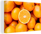 Une demi-orange sur un tas d'oranges 120x80 cm - Tirage photo sur toile (Décoration murale salon / chambre)