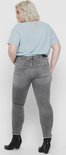 Achterkant van vrouw in grijze skinny jeans met rafelende zoom.