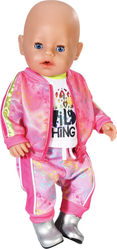 Pop met blauwe ogen, gekleed in een witte t-shirt en roze trainingsbroek met print. Zilveren laarsjes.