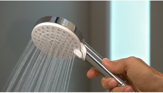 Hand houdt zilverkleurige handdouche vast waar water uit stroomt