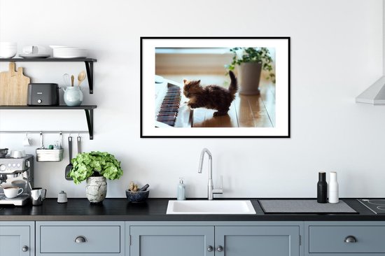 Chaton jouant avec un cadre photo piano noir avec passe-partout blanc 60x90