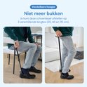 Man gebruikt verstelbare schoenlepel zittend en staand om schoenen aan te trekken.